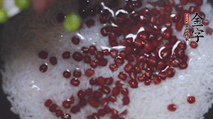 將炒好的食材和大米、紅豆一起放進(jìn)電飯鍋煮。