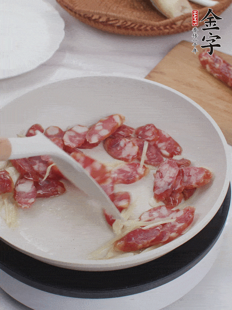 油溫3成熱時(shí)，下姜絲、蒜片、香腸炒出油脂。