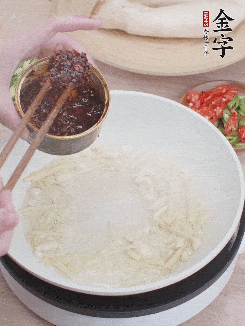 起鍋熱油，姜蒜、金字火腿干貝醬煸香。