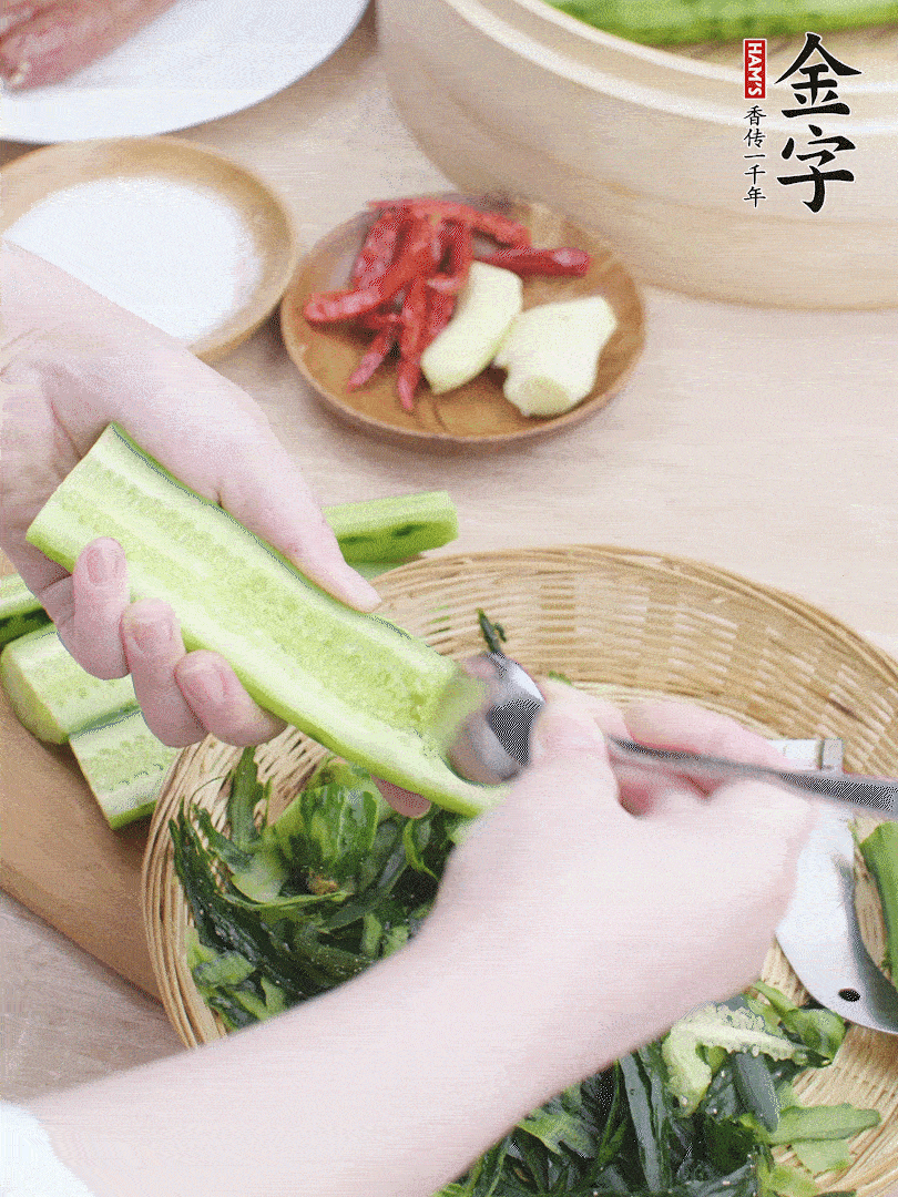 黃瓜削皮，對(duì)半切開(kāi)，勺子挖去內(nèi)瓤，斜刀切片。青蒜斜刀切段。
