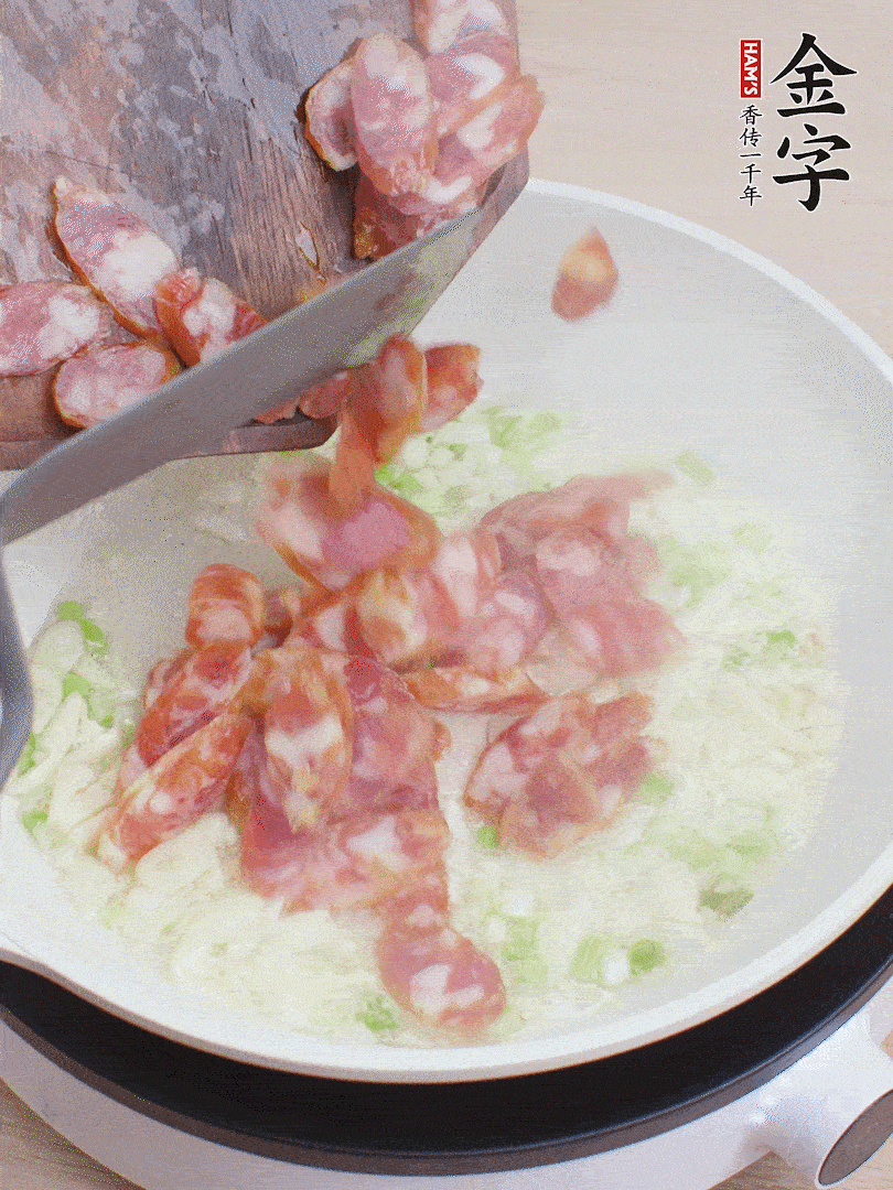 油5成熱，蒜末、蔥白爆香，下香腸炒出香味。