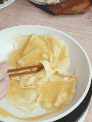 油6成熱時(shí)，下雞蛋液，邊緣凝固時(shí)翻拌成塊狀。