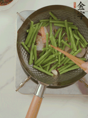 下掰好的缸豆段翻炒，略燜煮。